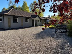 a house with a gravel driveway in front of it at Craigdarroch Guest House in Contin +36 photos