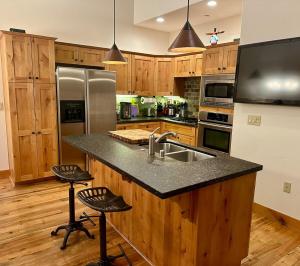 a kitchen with a sink and two bar stools at Cozy Light Filled Truckee Downtown in Truckee +20 photos