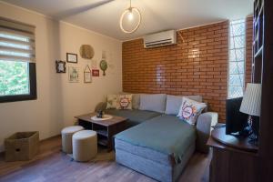 a living room with a couch and a brick wall at Happy house in Velika Remeta +42 photos