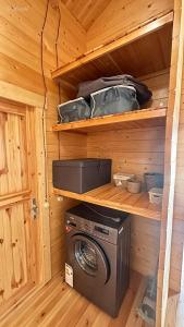 a wooden cabin with a washing machine in it at chemtan cottages in Dushetʼi +2 photos