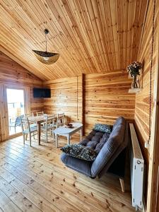 a living room with a couch in a wooden room at chemtan cottages in Dushetʼi