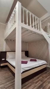 a bedroom with a white bunk bed and stairs at Vinnytsia City Center Guest House in Vinnytsya