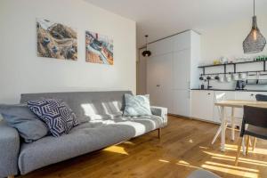 a living room with a couch and a table and a kitchen at Pino Home in Neringa