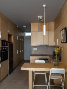a kitchen with wooden cabinets and a wooden table and chairs at Downtown photographer's studio in Korinthos