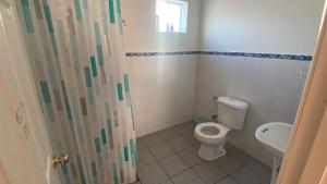 a bathroom with a toilet and a sink at Cabañas Wiñaypacha Putre in Putre