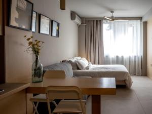 a living room with a bed and a table with chairs at Downtown photographer's studio in Korinthos