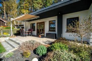 a house with a patio with a table and chairs at Waterkieker Jabel - Ferienhaus mit Sauna & Steg in Jabel