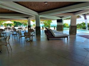a patio with tables and chairs and a pool at Hotel La Mariposa in Manuel Antonio