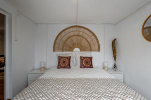 a white bedroom with a large bed with pillows at Casa Dos Arcos Oceanfront Apartments in Arcos