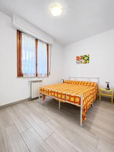 a bedroom with a bed with an orange blanket at Casa Berso' a Marina di Cecina by Zoom In Earth in Marina di Cecina