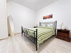 a bedroom with a black bed and a dresser at Casa Berso' a Marina di Cecina by Zoom In Earth in Marina di Cecina