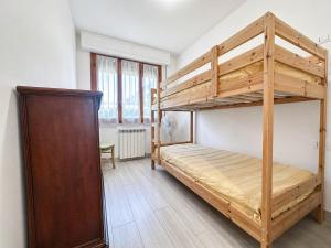 a bedroom with a bunk bed and a wooden cabinet at Casa Berso' a Marina di Cecina by Zoom In Earth in Marina di Cecina