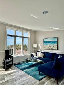 a living room with a blue couch and a blue rug at Oceanfront Escape on the Cabot Trail by Cabotopia in Chéticamp