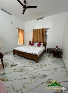 a bedroom with a bed and a ceiling fan at Peak Vagamon in Vagamon