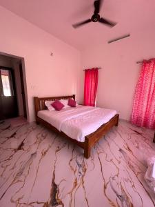 a bedroom with a bed and a ceiling fan at Peak Vagamon in Vagamon