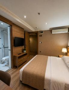 a bedroom with a bed and a flat screen tv at Prens Hotel Istanbul by GKRY Hotels Group - Tram And Metro Stops Are Just a Few Min Walk Away in Istanbul +20 photos
