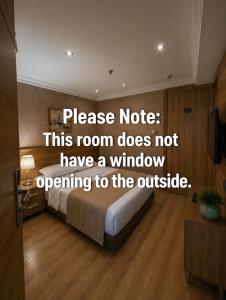a bedroom with a bed with a sign that reads please note this room does not at Prens Hotel Istanbul by GKRY Hotels Group - Tram And Metro Stops Are Just a Few Min Walk Away in Istanbul