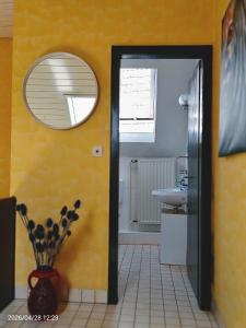 a bathroom with a mirror and a yellow wall at Ferienhaus Medebach in Medebach +16 photos