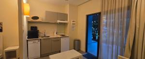 a small kitchen with a sink and a door to a room at Cosy Holidays in Trou aux Biches