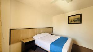 a bedroom with a bed and a picture on the wall at Hotel Plaza del Ángel in Huajuapan de León +11 photos