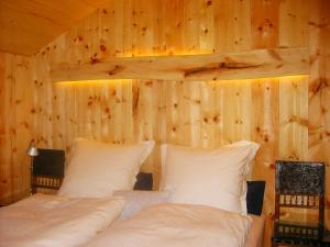 a bedroom with two beds and a wooden wall at Mountain House With Sauna In Sachrang in Sachrang