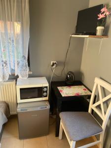 a small kitchen with a microwave and a table at Pokój u Patki in Rowy
