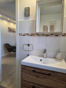 a bathroom with a sink and a mirror at Pension Zur Brandung in Büsum +112 photos