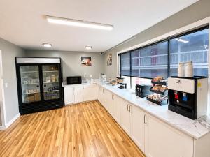 a large kitchen with white cabinets and a large window at Sunnyside Inn and Suites in Clackamas