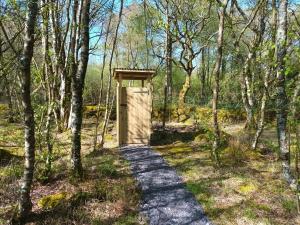 a wooden structure in the middle of a forest at Green woodland bell tent in Ynys Station +6 photos
