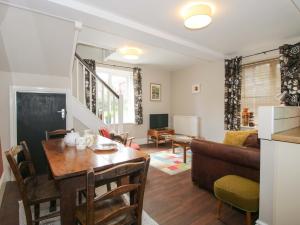 a kitchen and living room with a table and a couch at Little Pentwyn in Hereford