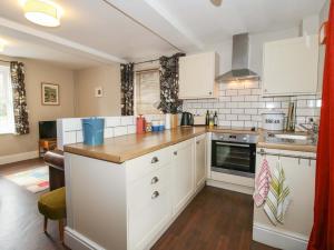 a kitchen with white cabinets and a counter top at Little Pentwyn in Hereford