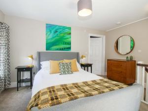 a bedroom with a bed and a dresser and a mirror at Little Pentwyn in Hereford