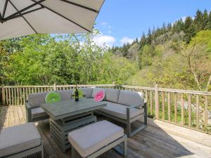 a patio with a couch and a table on a deck at Little Pentwyn in Hereford