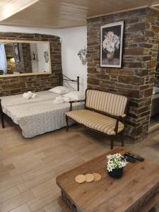 a bedroom with a bed and a chair and a table at villa lena πετρινο in Katákoilos