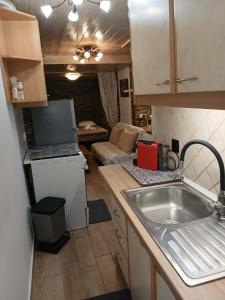 a kitchen with a sink and a living room at villa lena πετρινο in Katákoilos