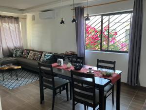 a living room with a table and chairs and a couch at F2 Farmhouse in Omuthiya