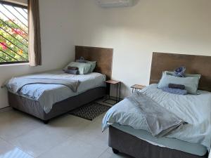 two beds sitting next to each other in a room at F2 Farmhouse in Omuthiya