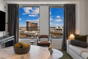 a living room with a table and a large window at Hyatus Designer Residences Somerville in Somerville