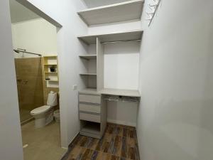 a bathroom with a toilet and a walk in closet at Aguakey in Tauramena