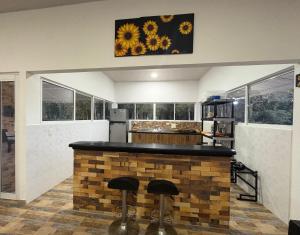 a kitchen with a brick bar with stools at Aguakey in Tauramena +8 photos