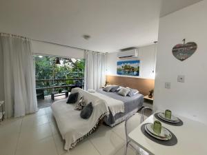 a bedroom with a bed and a large window at Villas do Pratagy Bambu 2 in Maceió