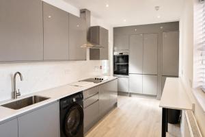 a kitchen with white cabinets and a washer at ExecStay - Central Reading - Premium Solo Stays in Reading