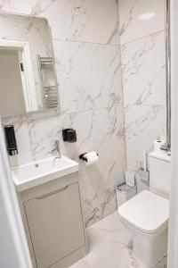 a white bathroom with a sink and a toilet at ExecStay - Central Reading - Premium Solo Stays in Reading