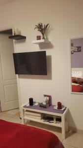 a living room with a tv on a wall at Chambre chez l'habitant proche mer in Saujon