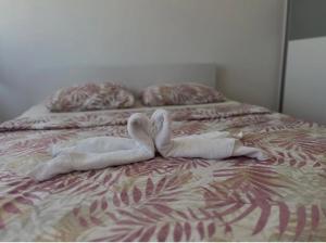 two white swans laying on top of a bed at Stan na dan Šamac in Bosanski Šamac