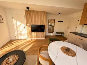 a living room with a table and a kitchen at Vistula Apartment in Ustroń