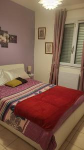 a bedroom with a bed with a red blanket on it at Chambre chez l'habitant proche mer in Saujon