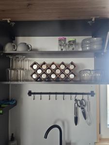 a kitchen with a shelf with pans and utensils at Bodensee Living Ferienwohnung Wald in Wald