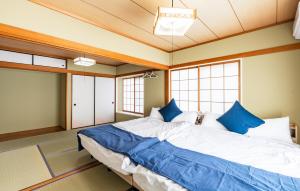 a bedroom with a large bed with blue pillows at Ninja Village - Miyajima in Hatsukaichi