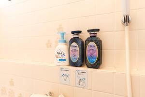 three bottles of cleaner sitting on a shelf in a bathroom at Ninja Village - Miyajima in Hatsukaichi +70 photos